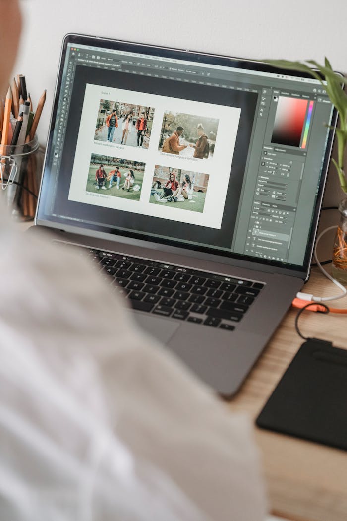 Photographer retouching images on a laptop using editing software at a home desk setup.